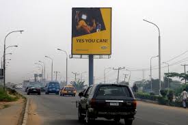 Portrait Billboard at Jakande Market showcasing a bright advertisement along a busy Lagos road., Billboards at Jakande Market